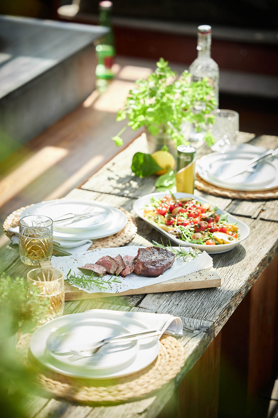 Gedeckter Tisch mit Grillfleisch und Gemüse